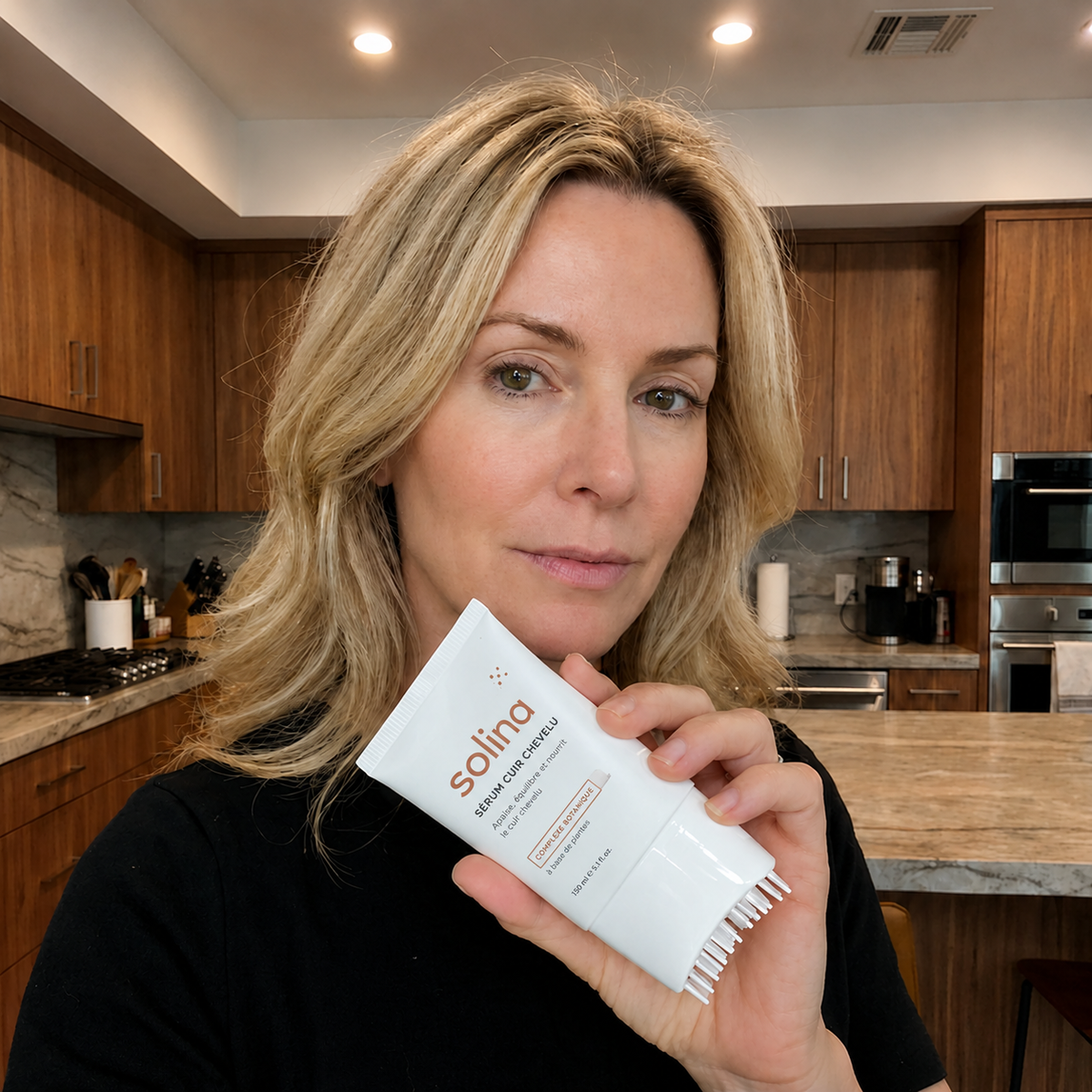 Cliente Solina presentant le serum cuir chevelu dans sa cuisine