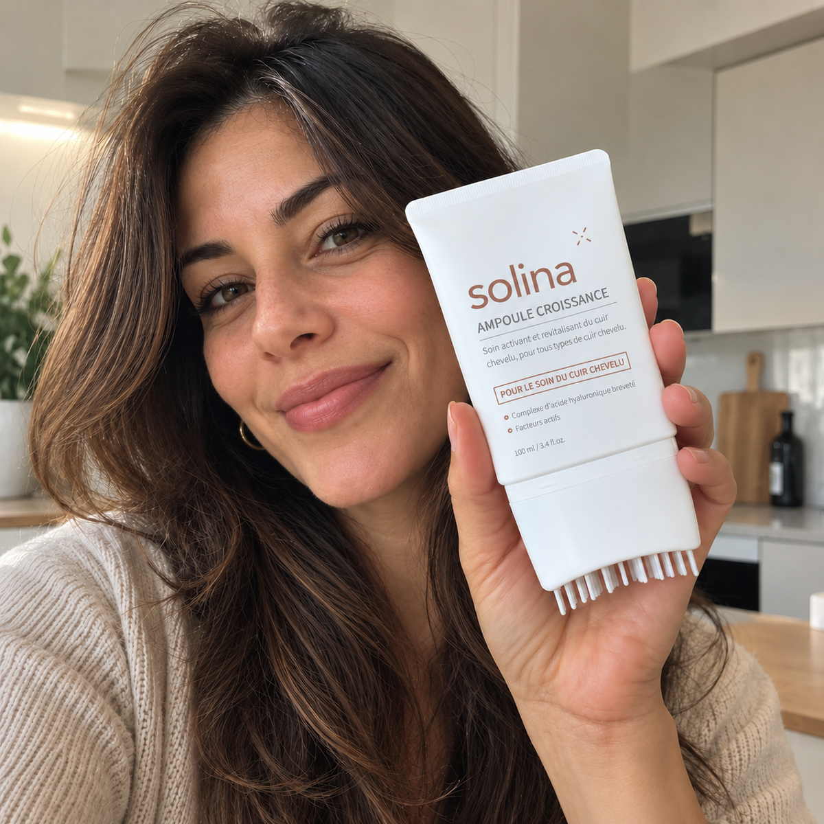 Cliente Solina souriante avec l'ampoule croissance dans sa cuisine